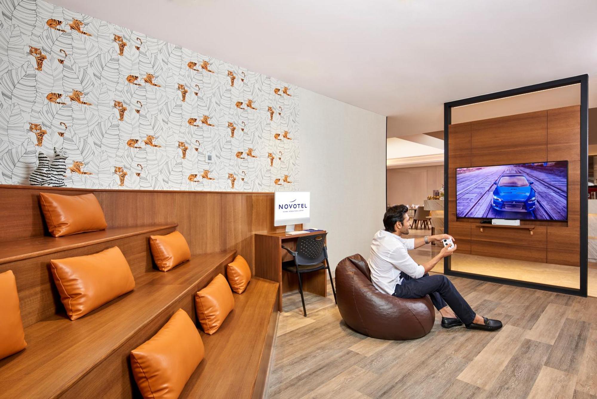 Novotel Mumbai International Airport מראה חיצוני תמונה A man playing a video game at the lounge